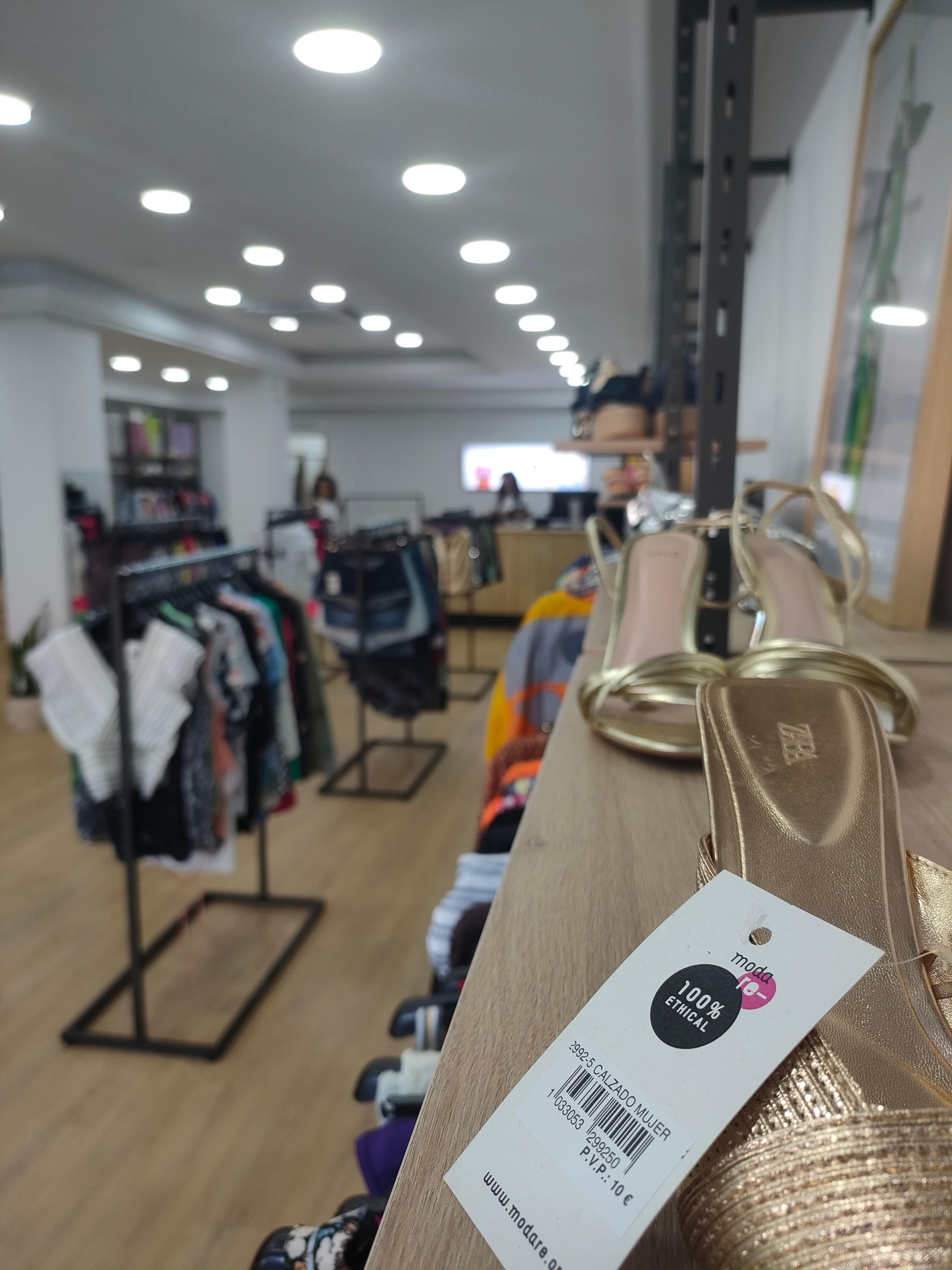 Interior de la tienda Moda re-: percheros con ropa de segunda mano